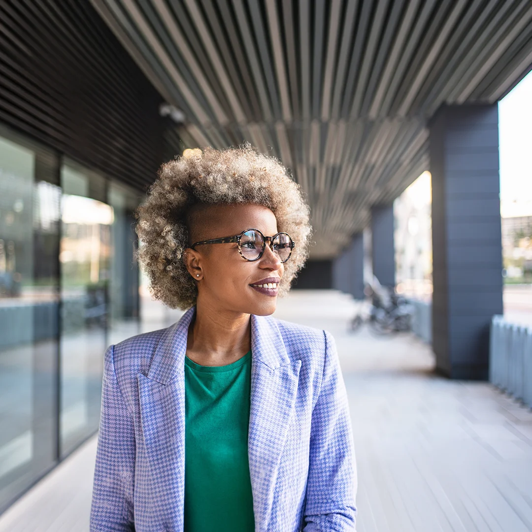 Confident professional leader walking through a modern office corridor, representing executive coaching, leadership growth, and forward movement